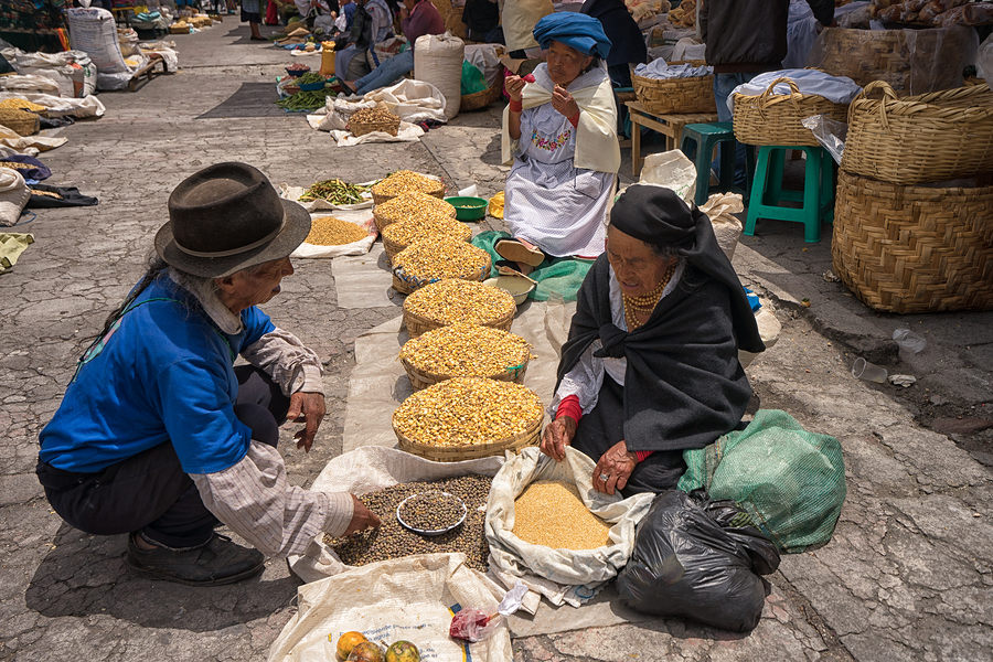 Indigenous quechua people selling produce from the ground on the street in the Saturday market