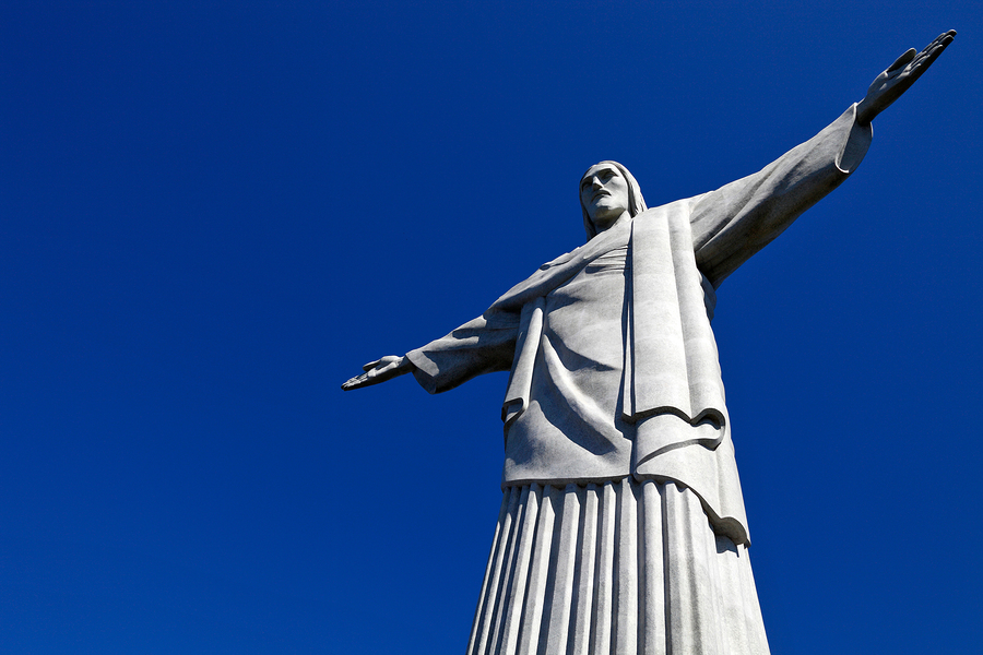 A view of Christ the Redeemer from below and underneath a blue sky.