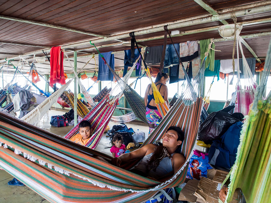 People are resting on hammocks on a deck of the cargo boat on the Amazon.