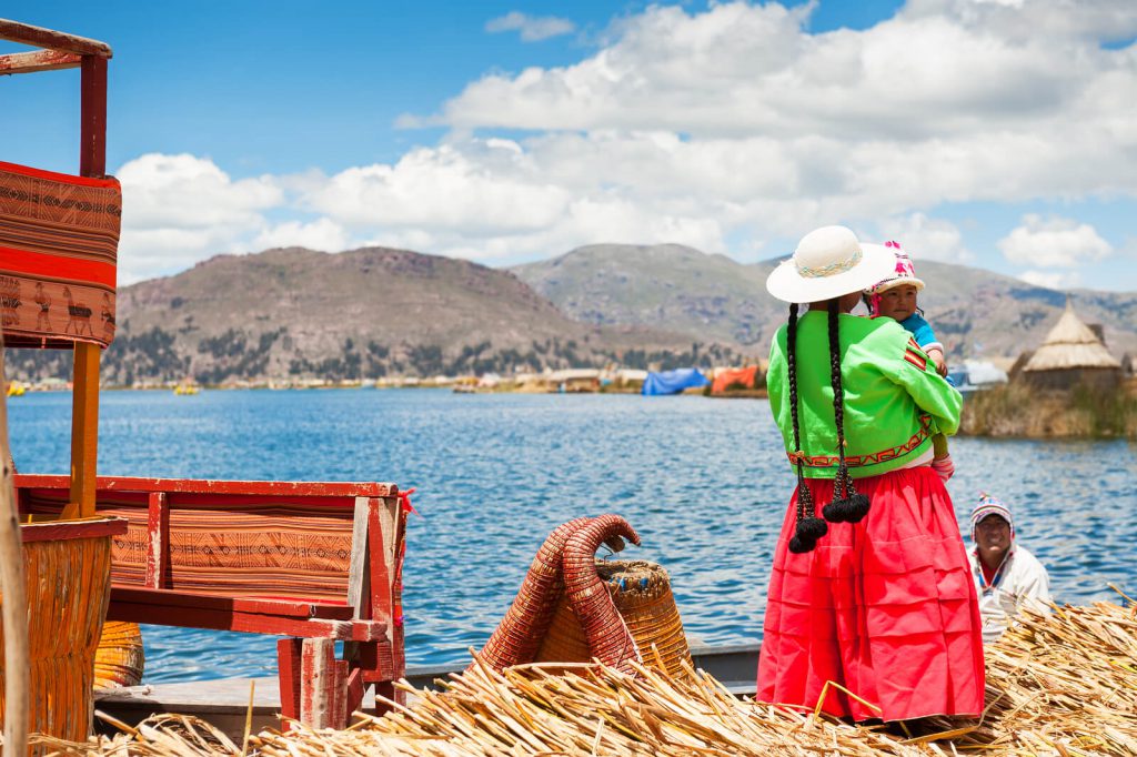 Picture of a lady watching over Lake Titicaca with her children.