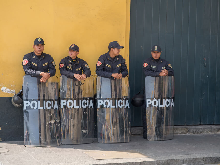 Police relax in a street in Lima.