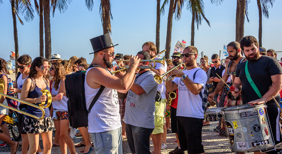 People playing music by the beach at a summer festival in Brazil.