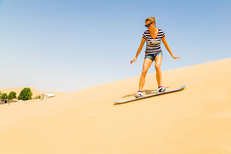 A picture of a lady sandboarding in South America.